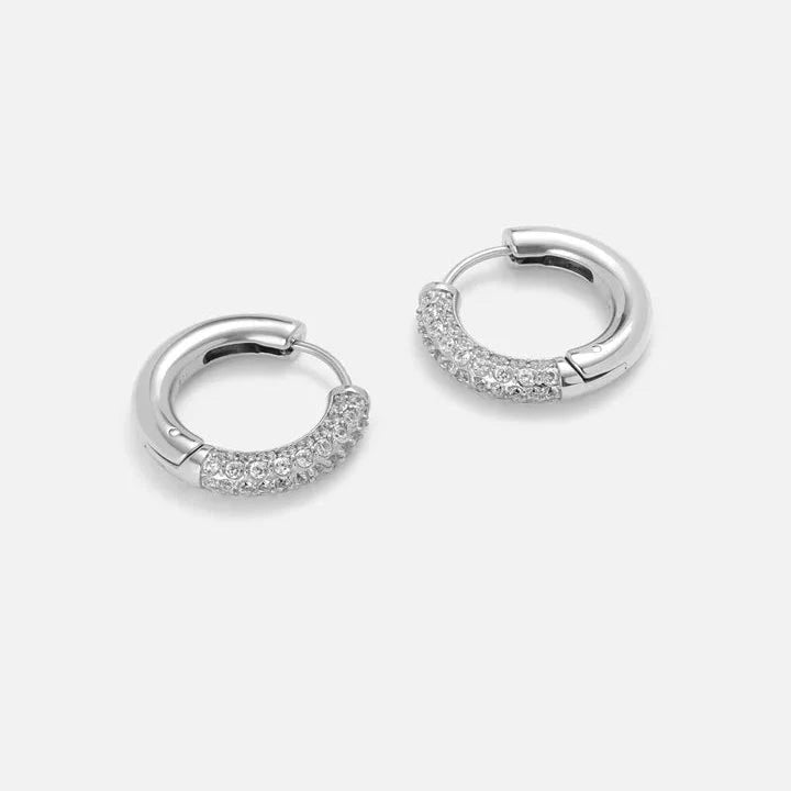 Silver pavé cubic zirconia huggie hoop earrings, pair on studio background