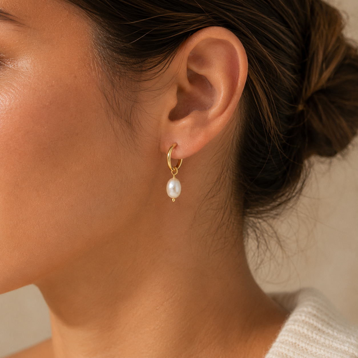 Model wearing gold freshwater pearl drop hoop earring