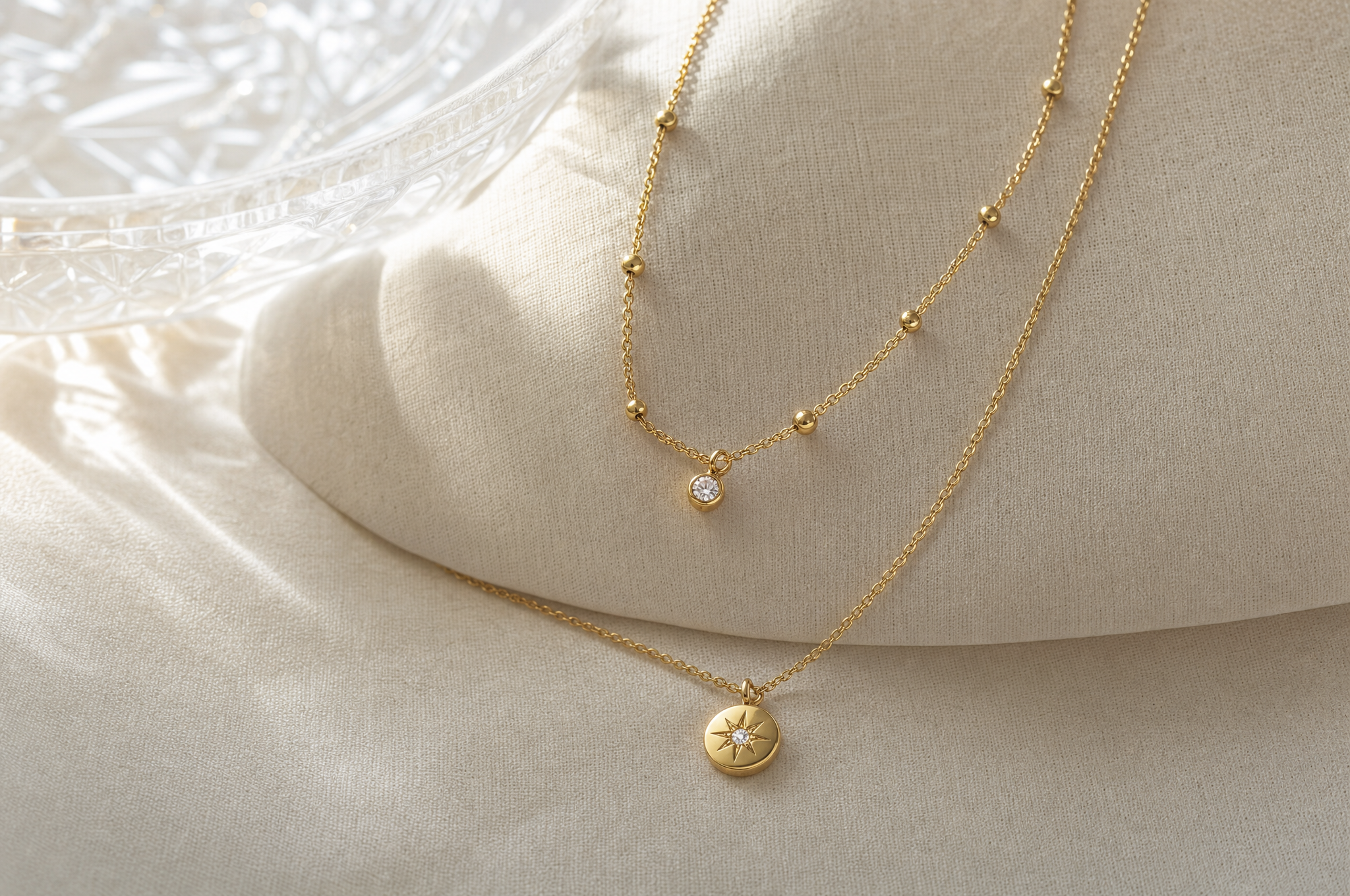 Gleaming layered 18K gold necklace on ivory linen