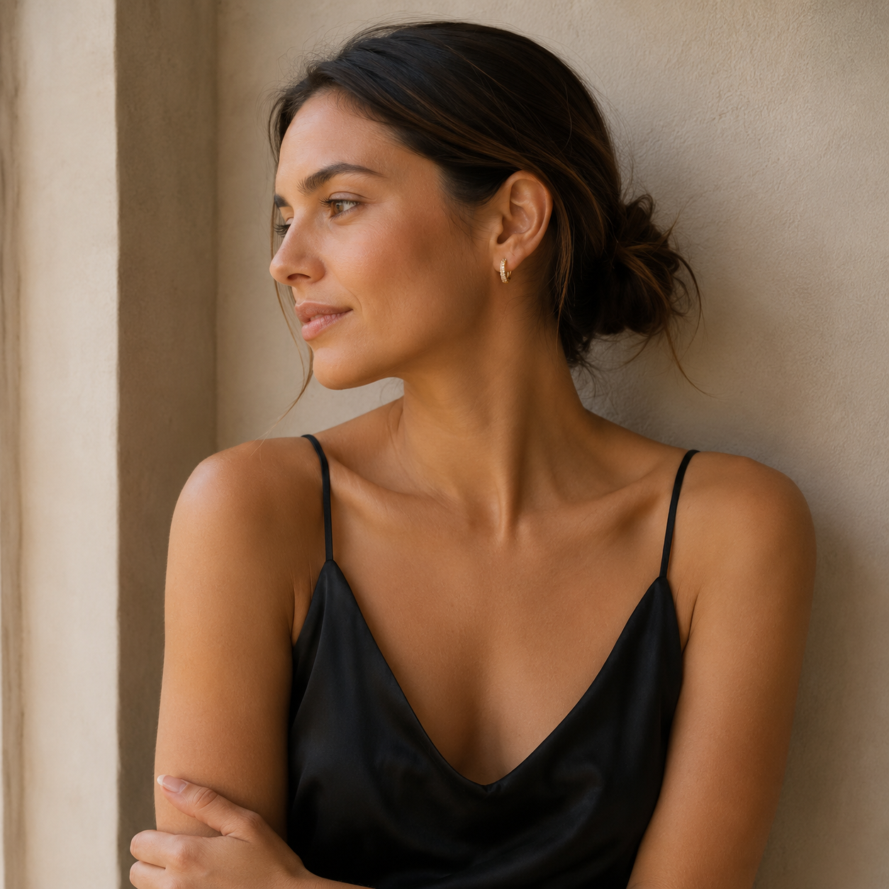 Woman wearing gold pavé huggie earrings